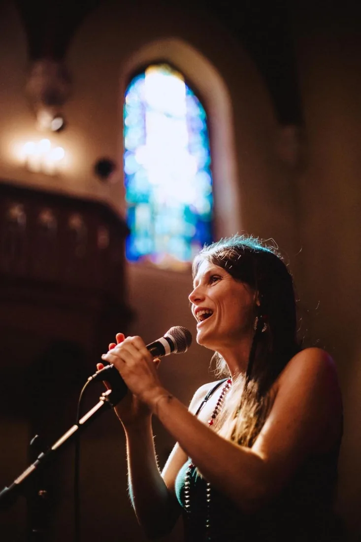 Floriane chante au micro dans une chapelle
