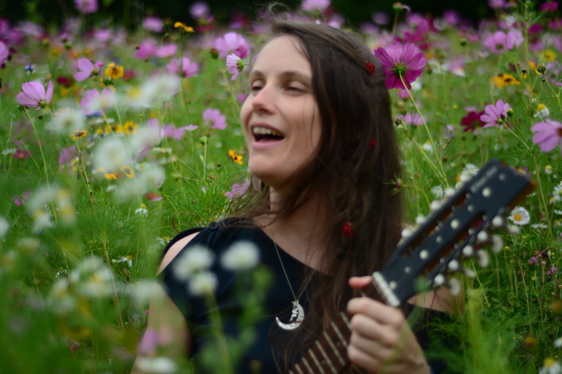 Floriane chante à la guitare au milieu des fleurs.
